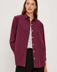 Woman wearing a burgundy striped shirt on a white background front view