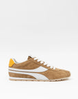 Tan sneaker with white accents on a light gray background
