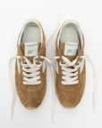 Pair of brown sneakers with white laces on a white background