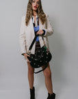 Woman wearing Faux Leather Boyfriend Blazer holding a black handbag against a plain background