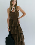 Woman wearing a brown tiered dress with a white background