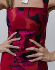 Person wearing a vibrant red and black patterned set with a plain background
