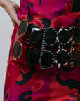 Person holding a collection of sunglasses against a plain background