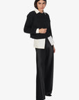 Person wearing a black and white outfit on a white background