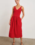 Woman wearing a red dress against a plain background front view