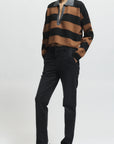 Person wearing a brown and black striped sweater with a white background