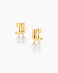 Gold hoop earrings with pearl drops on a white background