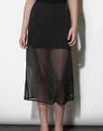 Black sheer skirt with sparkling details worn by a person on a white background