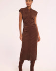 A model wearing a brown sleeveless midi dress with a button-down front and gathered waist, paired with matching brown boots, against a plain off-white background.