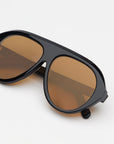 Sunglasses with brown lenses and black frame on a white background