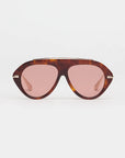 tortoise sunglasses with gold accents and light red lenses on a grey background