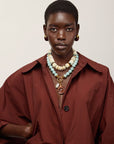 Toro Earrings in Aubergine on model with red coat