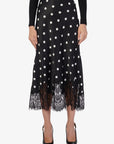 Black polka dot skirt with lace trim on a white background