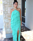 Woman wearing a light blue halter neck dress standing outdoors, full body front
