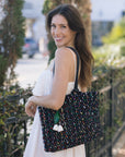 Woman holding a colorful tote bag outdoors
