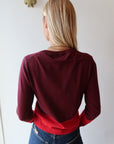 Person wearing a red sweater and blue jeans, back
