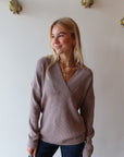 Woman wearing a brown sweater and blue jeans