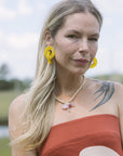 Woman with yellow earrings and Mich Necklace
