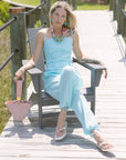 Woman in a light blue matching set sitting on a wooden bench outdoors.