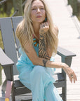 Woman in a blue matching set sitting on a wooden bench outdoors