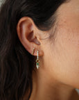 Single Tiny Emerald Pyramid Charm extreme close up side view on model