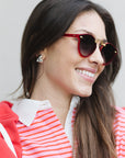 Woman wearing red heart-shaped sunglasses and a red and white striped shirt.