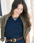 Aila choco leather belt on a model with a blue dress and green sweatshirt over her shoulders