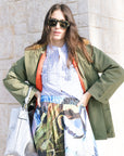 The Quilted Liner Parka open on model with stripe button down and print skirt and silver bag