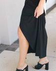 Fizz long drape skirt on a model with black heels zoomed in on the side