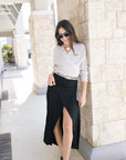 Fizz long drape skirt on a model with a cream wrap sweater and black heels front view showing slit