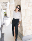 Fizz long drape skirt on a model with a cream wrap sweater and black heels front view