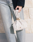 model wearing light blue jeans covered in rhinestones and a dark jacket holding a purse