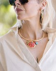Woman wearing a gold necklace with seashell and starfish charms, sunglasses, and Nicolette 2" Earrings.