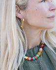 Close-up of a woman wearing colorful beaded necklace and Earrings Iona