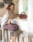 Woman sitting at a bar counter with a brown handbag next to her