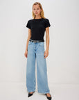 Woman wearing a black t-shirt and light blue jeans on a white background front view