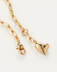 Gold chain necklace with a heart-shaped pendant on a white background, close up
