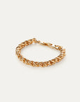 Gold chain bracelet on a light beige background