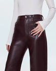 Brown leather pants worn by a person on a light gray background front view