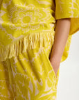 Yellow set with floral pattern and fringes on a white background