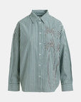Green and white striped shirt with decorative elements on a light gray background
