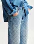 Person wearing a blue denim shirt and jeans on a white background