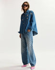 Person wearing a blue denim outfit with a white background