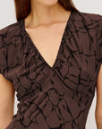Brown patterned dress worn by a model on a plain background