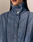 close up of a model wearing a denim jacket with the high collar