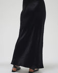 Black satin skirt worn by a person on a white background