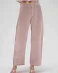 Pink pants worn by a person on a white background