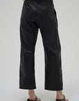 Black pants worn by a person on a white background back view