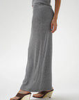 Person wearing a long gray skirt on a white background
