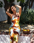 Sicily Dress front view on model sitting down with her hands in her hair